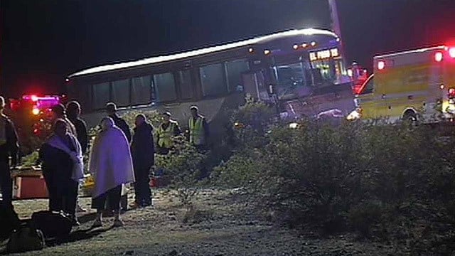 Passengers wait outside a Greyhound bus after its driver brought it to halt when two passengers